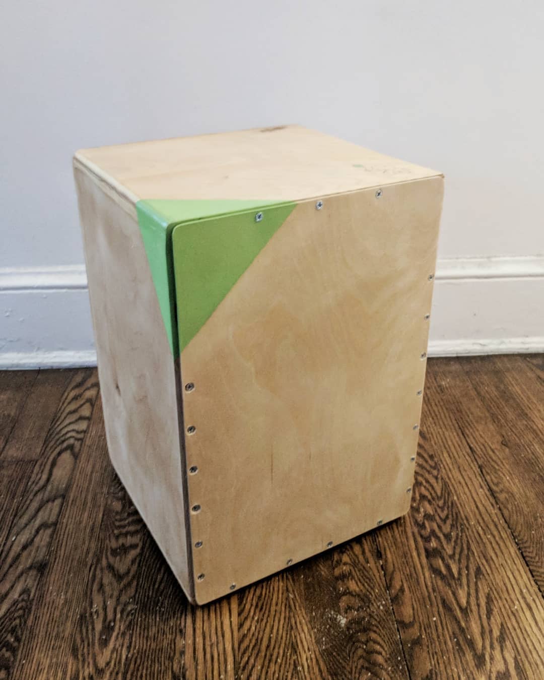A cajon box drum out of plywood, with a drawing of an elephant on the corner.