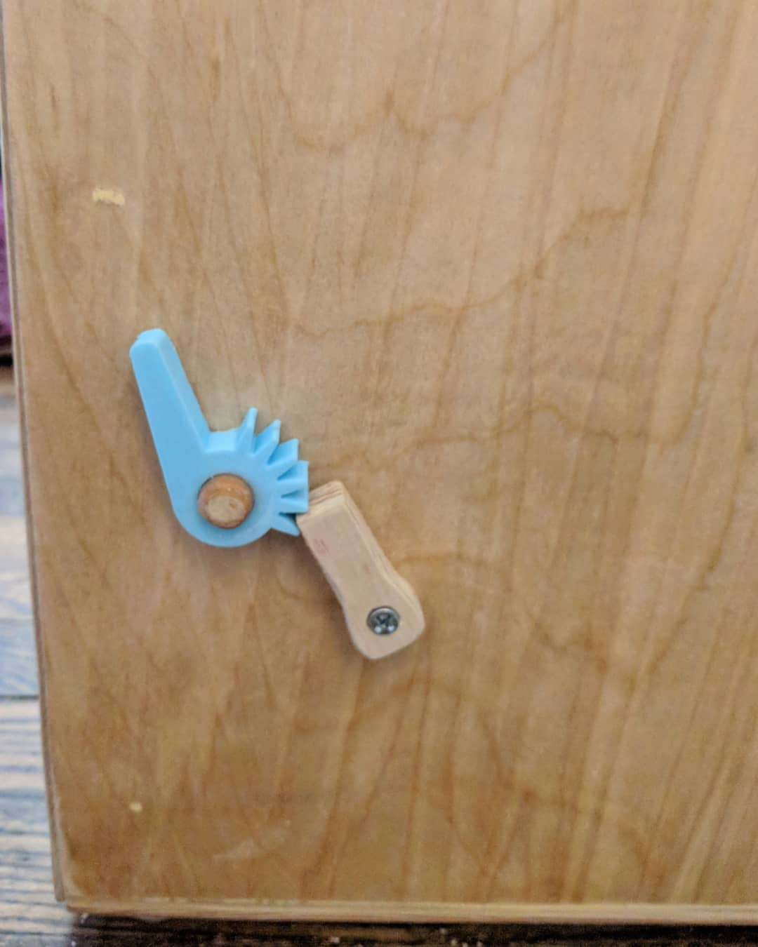 A close-up of the snare adjustment gear and lock for the cajon drum.